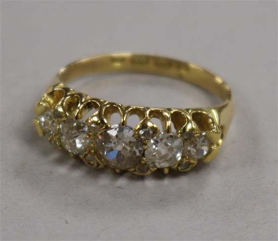 A late Victorian 18ct gold and graduated five stone diamond half hoop ring with rose cut diamond spacers, size K.